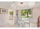 Bright dining room featuring a glass table, white chairs, and a large window with a view of the yard at 9329 W Topeka Dr, Peoria, AZ 85382