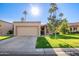 Charming single-story home featuring a two-car garage, well-manicured lawn, and towering palm trees in sunny Arizona at 9329 W Topeka Dr, Peoria, AZ 85382