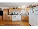 Well-organized kitchen with wooden cabinets, white appliances, and ample counter space for meal preparation at 97 W Marilyn Way, San Tan Valley, AZ 85140