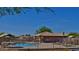 View of a community pool with lounge chairs and tables, fenced in, with a covered area for shade and relaxation at 10332 W Potter Dr, Peoria, AZ 85382