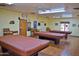 Game room with three billiard tables, ceiling fans, and chairs, providing a recreational space for residents at 10332 W Potter Dr, Peoria, AZ 85382