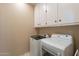 Functional laundry room features upper cabinets and modern washer and dryer at 10332 W Potter Dr, Peoria, AZ 85382