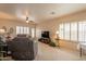 Inviting living room with plantation shutters, ceiling fan, carpet flooring and cozy furnishings at 10332 W Potter Dr, Peoria, AZ 85382