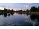 Scenic view of a pond reflecting the sky at dusk, surrounded by trees and landscaping, creating a serene atmosphere at 10332 W Potter Dr, Peoria, AZ 85382