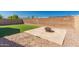 Wide backyard with artificial turf, fire pit, rock landscaping, and tall brick wall at 10704 E Plata Ave, Mesa, AZ 85212