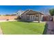 Exterior shot of back yard featuring grass and a covered patio at 10704 E Plata Ave, Mesa, AZ 85212