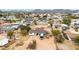 An aerial view of a property featuring a home, a yard, storage, and the surrounding neighborhood with mountain views at 11512 E 6Th Ave, Apache Junction, AZ 85120