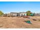 Spacious backyard featuring a white single-story home, storage sheds, and potential for outdoor activities at 11512 E 6Th Ave, Apache Junction, AZ 85120