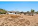 A large dirt backyard showcasing the property and the 11512 address sign at 11512 E 6Th Ave, Apache Junction, AZ 85120