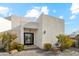 Modern home entrance with a black front door, desert landscaping, and a bright blue sky at 12201 N 66Th St, Scottsdale, AZ 85254