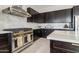 This is a modern kitchen with stainless steel appliances, dark wood cabinets, and a white tiled backsplash at 12201 N 66Th St, Scottsdale, AZ 85254