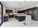 Stylish kitchen with a waterfall island, dark cabinets, stainless steel appliances, and modern pendant lighting at 12201 N 66Th St, Scottsdale, AZ 85254