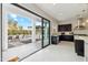 Modern kitchen with dark cabinetry, stainless steel appliances, and a view of the outdoor patio and pool at 12201 N 66Th St, Scottsdale, AZ 85254