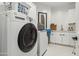 This is a well-organized laundry room with a washer, dryer, sink, and storage cabinets at 12201 N 66Th St, Scottsdale, AZ 85254