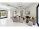 Spacious living room with neutral furnishings, white tile floors, and a large ceiling fan at 12201 N 66Th St, Scottsdale, AZ 85254