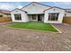 Lush backyard featuring artificial grass, gravel, and a covered patio, perfect for outdoor entertaining at 12858 W Pasaro Dr, Peoria, AZ 85383