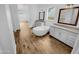 Bright bathroom featuring dual vanities, a standalone tub, and wood-style tile flooring at 12858 W Pasaro Dr, Peoria, AZ 85383