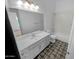 Bathroom featuring decorative tile floors, white cabinetry, a large mirror, and a tub-shower combination at 12858 W Pasaro Dr, Peoria, AZ 85383