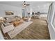 Bright, open living room showcases hardwood floors and a seamless transition into a modern, white kitchen at 12858 W Pasaro Dr, Peoria, AZ 85383