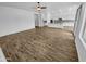 Bright living room showcasing wood-look floors, neutral walls, and a view into the open-concept kitchen at 12858 W Pasaro Dr, Peoria, AZ 85383