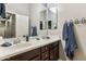 Bathroom featuring double sinks, a large mirror, and towel hooks at 13849 S 179Th Ave, Goodyear, AZ 85338