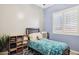 Bedroom with blue walls, shuttered windows, and decorative storage at 13849 S 179Th Ave, Goodyear, AZ 85338