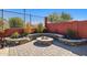 Outdoor living space featuring a stone fire pit with built-in seating and brick pavers at 13849 S 179Th Ave, Goodyear, AZ 85338