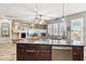 Modern kitchen island with a stainless steel sink, dishwasher, and views of the living room at 13849 S 179Th Ave, Goodyear, AZ 85338