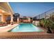 Backyard pool featuring brick pavers, stacked stone accents, landscaping, and an iron fence at 13849 S 179Th Ave, Goodyear, AZ 85338