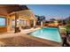 Backyard pool with brick pavers, a covered patio with an outdoor dining set, and lounge chairs at 13849 S 179Th Ave, Goodyear, AZ 85338