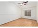 This bedroom features light wood flooring, a window for natural light, and a ceiling fan for comfort at 14404 N 56Th Pl, Scottsdale, AZ 85254