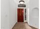 Inviting foyer featuring tile floors, a decorative wood door with glass inserts, and an entry light at 14404 N 56Th Pl, Scottsdale, AZ 85254