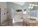 Bright bathroom with a glass block shower, separate tub, and natural light at 14447 N 100Th Way, Scottsdale, AZ 85260