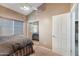 Bedroom featuring neutral tones, a ceiling fan, and a mirrored closet at 14447 N 100Th Way, Scottsdale, AZ 85260