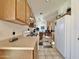 Kitchen with wood cabinetry, white appliances, and an open layout connecting to the dining area at 14545 S Cherry Hills Dr, Arizona City, AZ 85123