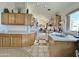 Bright kitchen with wood cabinetry, tile countertops, and a view into the adjacent dining area at 14545 S Cherry Hills Dr, Arizona City, AZ 85123