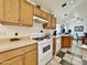 Well-equipped kitchen featuring wooden cabinets, white appliances, and ample counter space for food preparation at 14545 S Cherry Hills Dr, Arizona City, AZ 85123