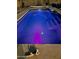 The inground pool is the perfect place to lounge even at night, with a vibrant purple hue at 14545 S Cherry Hills Dr, Arizona City, AZ 85123