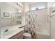 Bathroom features a shower-tub combination with rose-patterned curtain, along with a classic vanity at 15924 W Falcon Ridge Dr, Sun City West, AZ 85375