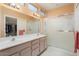 Bathroom featuring dual sinks, walk-in shower, and a walk-in closet at 15924 W Falcon Ridge Dr, Sun City West, AZ 85375