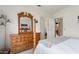 Comfortable bedroom featuring a dresser with mirror, and a four-poster bed with patterned throw blanket at 15924 W Falcon Ridge Dr, Sun City West, AZ 85375