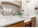 Bright bathroom features dual sinks, wooden cabinets and vanity, with a view of the shower and garden window at 16830 S Coleman St, Phoenix, AZ 85045