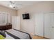 Bright bedroom with a ceiling fan, shuttered windows, a TV, and closet. Neutral decor and carpeted floors at 16830 S Coleman St, Phoenix, AZ 85045