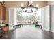 Bright dining area features a modern chandelier and a large window with a view of the sparkling pool and waterfall at 16830 S Coleman St, Phoenix, AZ 85045