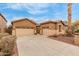 Spacious driveway leading to a three car garage with desert landscaping at 16830 S Coleman St, Phoenix, AZ 85045