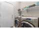 Functional laundry room with a modern washer and dryer set, storage shelves, and a door to the exterior at 16830 S Coleman St, Phoenix, AZ 85045