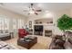 Inviting living room boasts a cozy fireplace, plush leather seating, and a ceiling fan for added comfort at 16830 S Coleman St, Phoenix, AZ 85045