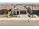 Aerial view of a home and community with tile roofs and desert landscaping at 17055 W El Caminito Dr, Waddell, AZ 85355