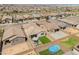 Aerial view of the backyard with a patio, artificial turf, seating, landscaped perimeter, pool and fence at 17055 W El Caminito Dr, Waddell, AZ 85355