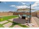 Well-maintained backyard featuring artificial grass, seating area, brick pavers, and privacy fence perfect for entertaining at 17055 W El Caminito Dr, Waddell, AZ 85355